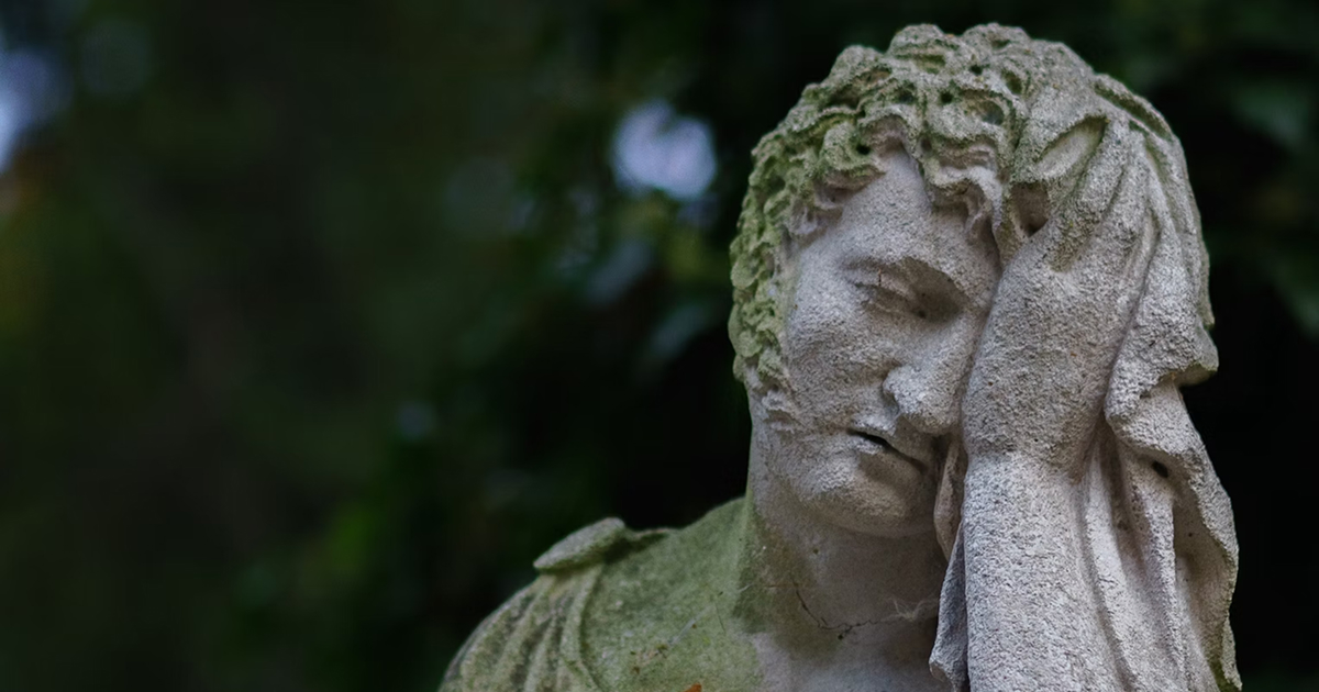 A marble statue of a man with his hand on his head